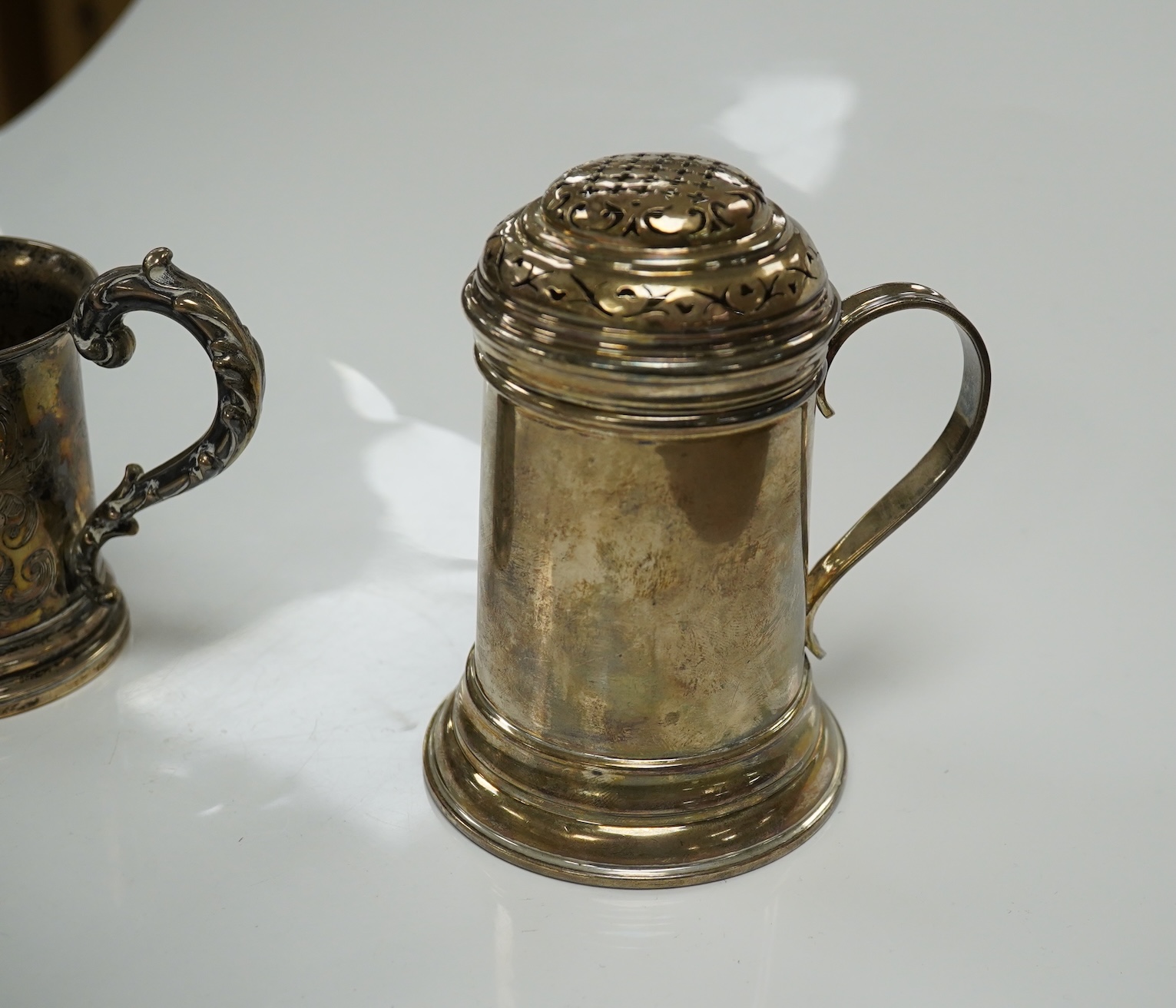 A George V Brittania standard silver kitchen pepper, by John Charles Lowe, London, 1935, 11.5cm and a Victorian silver christening mug, 10.4oz. Condition - poor to fair